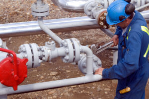 Field worker adjusting pipeline components in preparation for hydrostatic testing