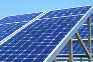 Technician applying Z-Maxx grease to a solar panel frame for corrosion protection.